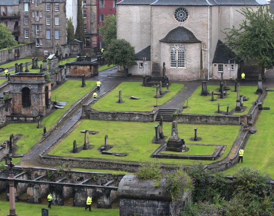 Police stand guard in the church graveyard as preparations begin for the wedding of Zara Phillips and Mike Tindall inside the Canonngate Kirk in Edinburgh, Scotland July 28, 2011. The Queens grandaughter Phillips will marry England rugby player Tindall a