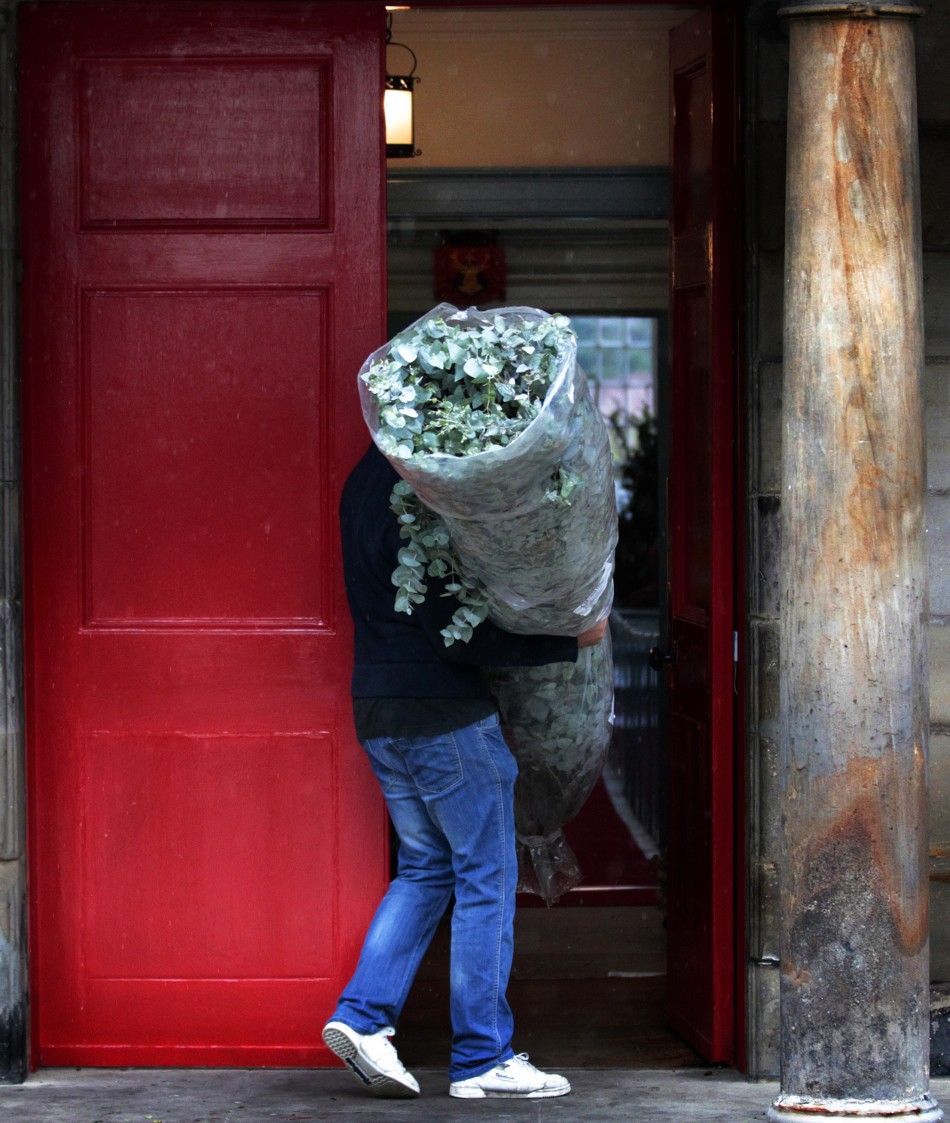 A man carries a floral decoration as preparations begin for the wedding of Zara Phillips and Mike Tindall, inside the Canonngate Kirk in Edinburgh, Scotland 
