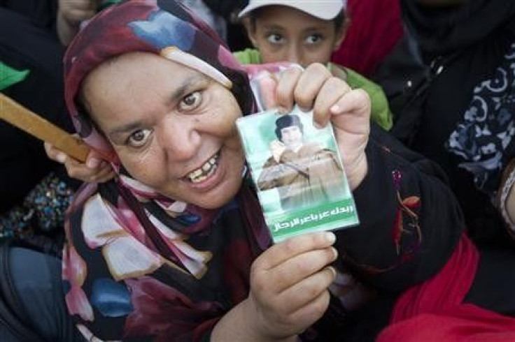 A woman holds a picture of Libyan leader Muammar Gaddafi
