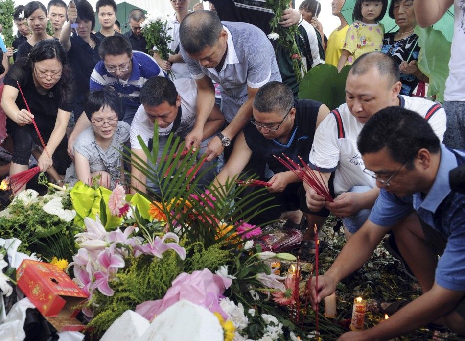 Local residents offer burning incense to mourn for victims of the train accident in Wenzhou, Zhejiang province