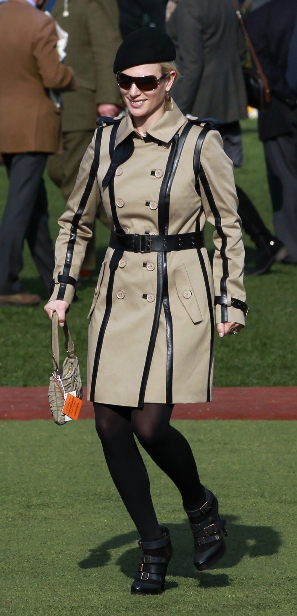 Britains Zara Phillips smiles as she walks through the unsaddling enclosure during the Cheltenham Festival horse racing meet in Gloucestershire