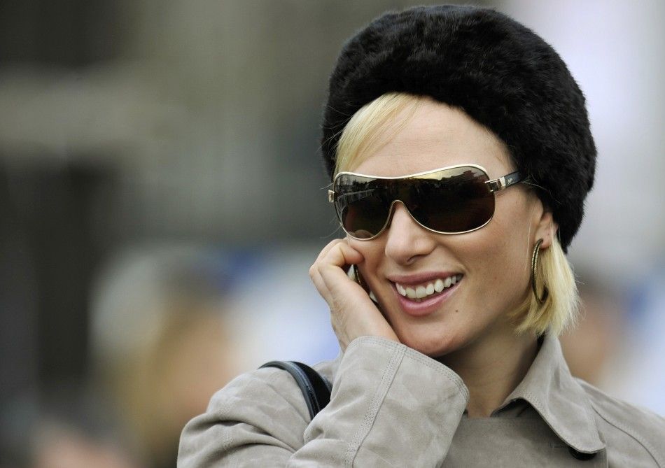 Britains Zara Phillips smiles as she watches the races at the Cheltenham Festival horse racing meet in England