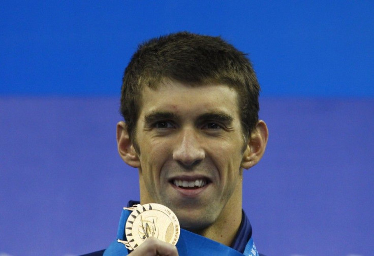 Phelps of the U.S. poses with his gold medal for the men&#039;s 100m butterfly final at the 14th FINA World Championships in Shanghai