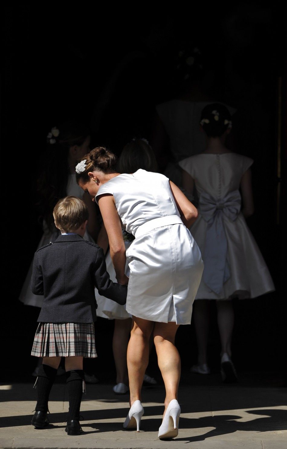 A page boy and bridesmaids arrive before the marriage of Britains Zara Phillips