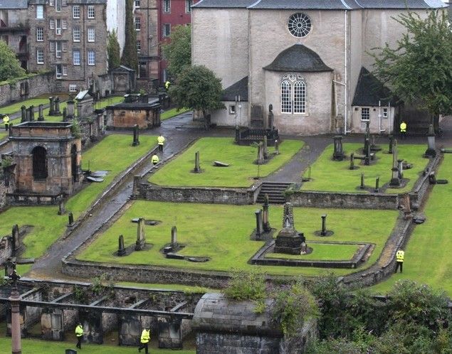  Police stand guard in the church graveyard as preparations begin for the wedding of Zara Phillips and Mike Tindall inside the Canonngate Kirk in Edinburgh