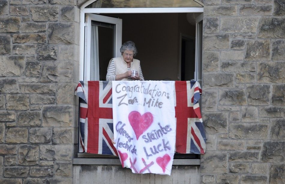  A women watches from her window before the marriage of Britains Zara Phillips and Mike Tindall in Edinburgh