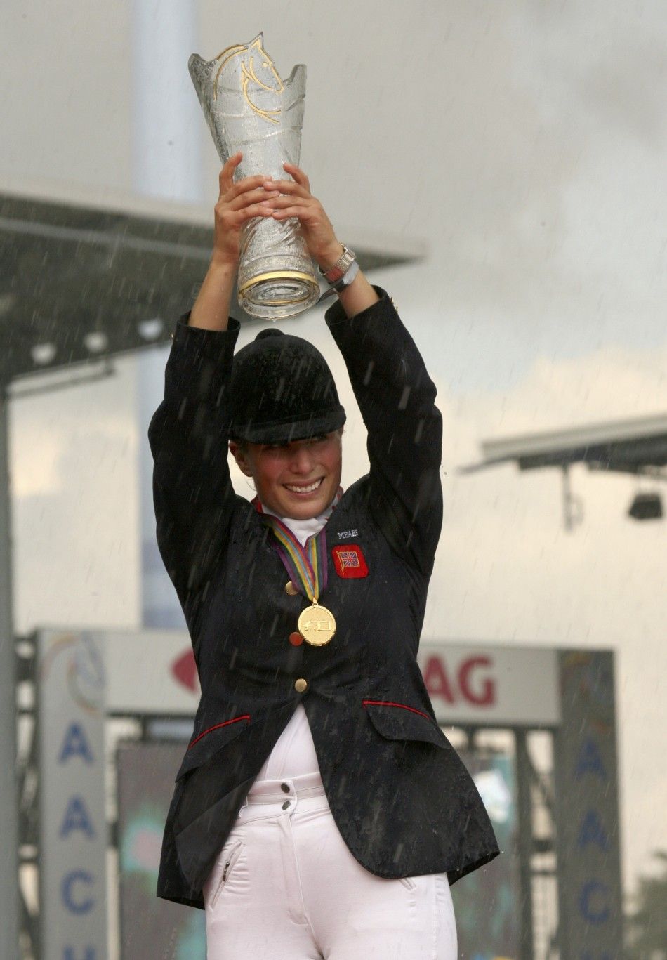 Eventing gold medal winner Britains Zara Phillips holds up the Sponsors cup at the World Equestrian Games in Aachen 