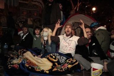 Protesters celebrate after they evaded eviction at the 12.01am deadline outside City Hall at the Occupy LA encampment in Los Angeles