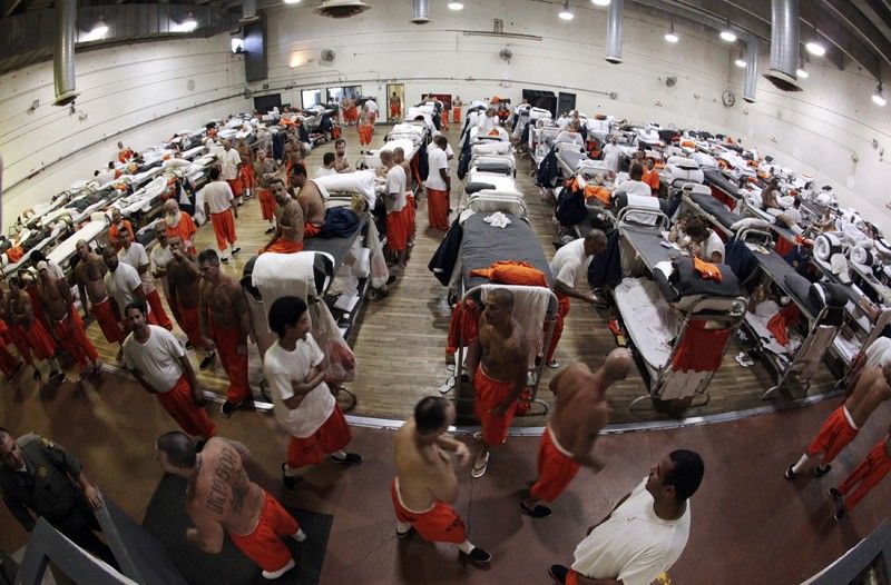 Inmates walk around a gymnasium