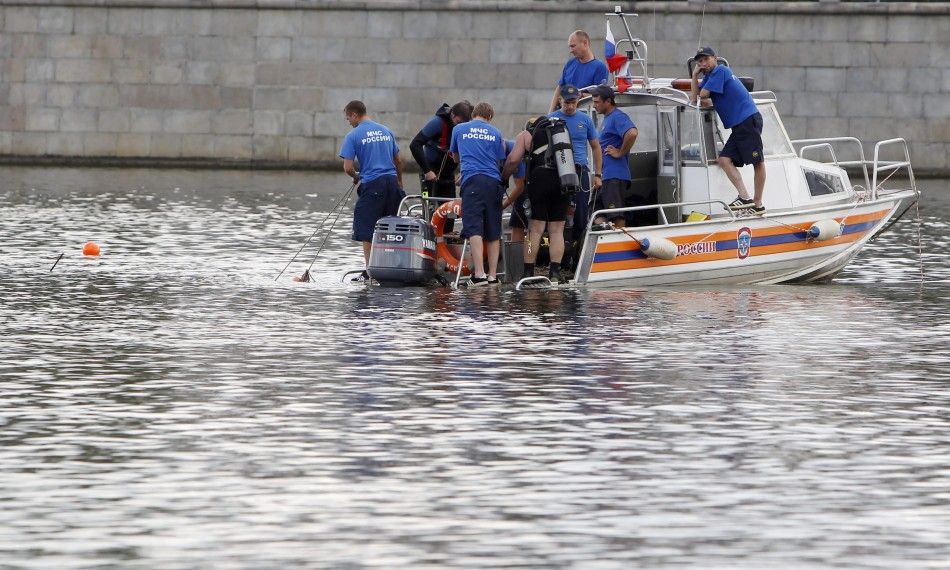 Emergency workers look for survivors following a crash between a private boat and river barge on the Moscow river in Moscow.