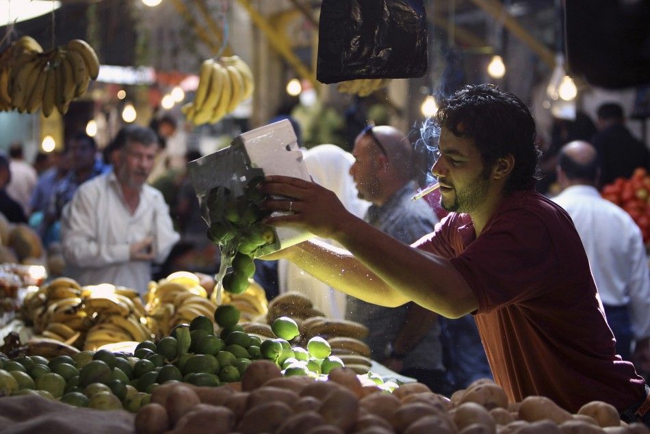 A vendor arranges limes on display as Jordanians shop in preparation for the Muslim holy month of Ramadan, at the downtown market area in Amman