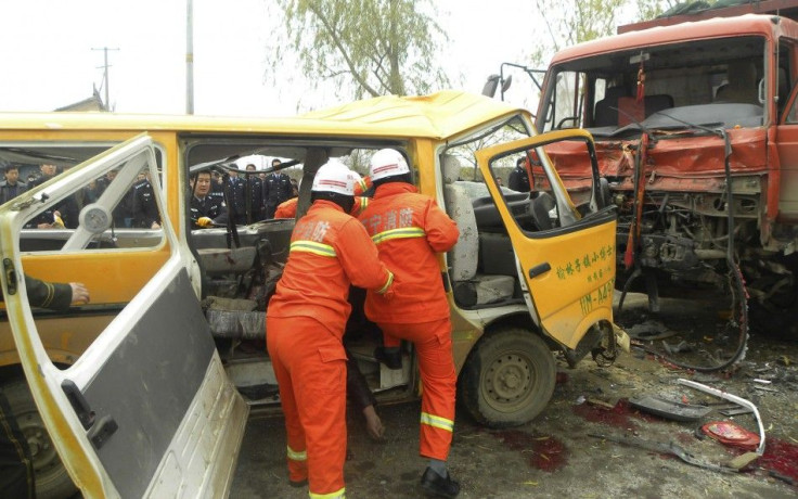 Rescuers pull a body out of a school bus after it collided with a truck at a traffic accident site in Yulinzi township of Zhengning county, Gansu province, November 16, 2011. Nineteen people, including 17 preschoolers and two adults, died in the head-on c