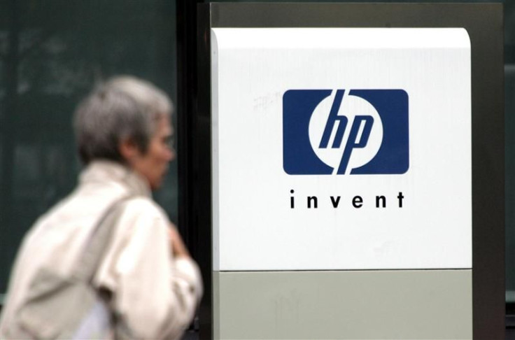 File photograph of a woman walking past the Hewlett Packard logo at its French headquarters in Issy le Moulineaux