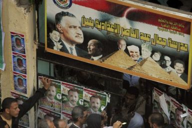People stand outside a polling station as they wait to cast their votes during parliamentary elections in Cairo