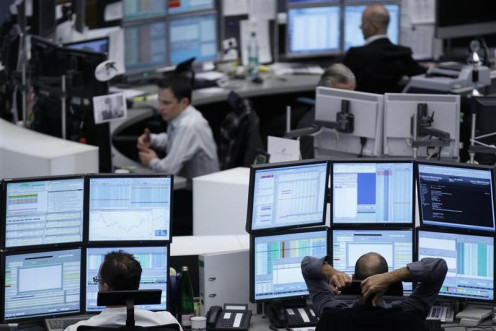 Traders work at their desks at the Frankfurt stock exchange