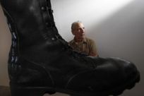 Joe Fornelli, artist liason for the National Veterans Art Museum, is seen beside Jon Turner&#039;s Prayer Boots in Chicago