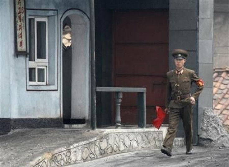 A North Korean soldier holds a red flag as he walks on the banks of Yalu River near the North Korean town of Sinuiju, opposite the Chinese border city of Dandong