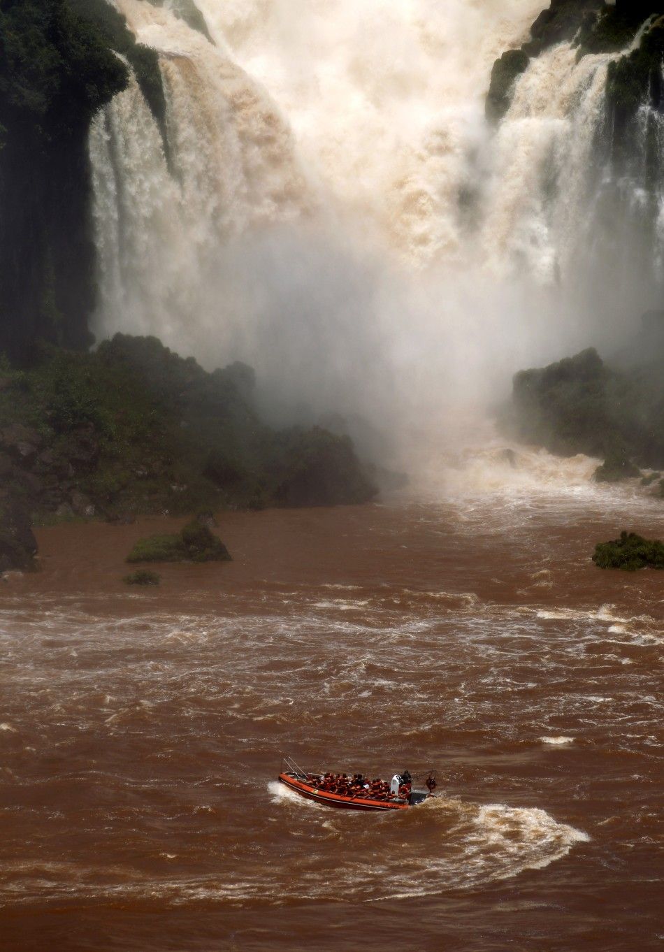 A boat carrying tourists sails by the Iguazu Falls on the border of Argentina039s province of Misiones and Brazil039s State of Parana.