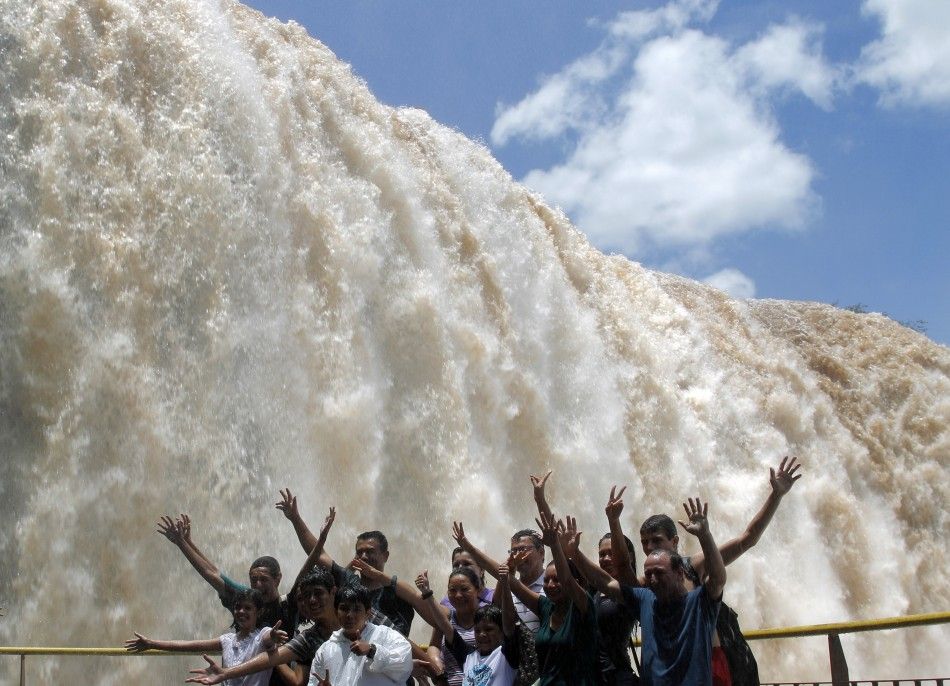 Tourists pose in front of the Iguazu Falls on the border of Argentina039s province of Misiones and Brazil039s State of Parana.