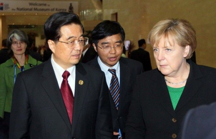 China's President Hu Jintao (L) talks with German Chancellor Angela Merkel as they arrive at the National Museum of Korea for dinner in Seoul November 11, 2010, on the first day of the G20 Summit. World leaders are gathering in Seoul on Thursday and Frida