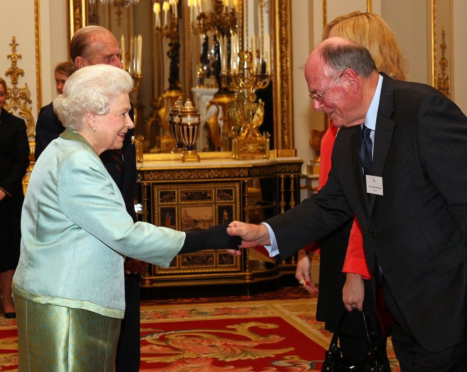 Britains Queen Elizabeth greets veteran Sun photographer Arthur Edwards R during a reception for members of the media at Buckingham Palace in London November 28, 2011.