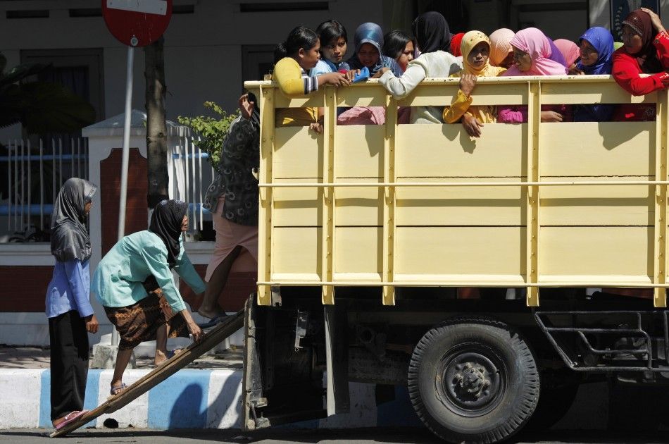 Indonesian Muslim women climb up a truck on a make-shift ladder on the way for prayers in Bojonegoro