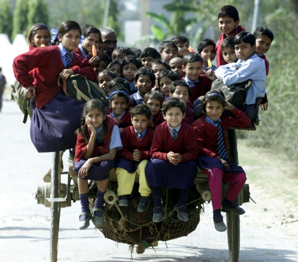INDIAN CHILDREN SIT AT THE HORSE CART WHILE COMING BACK FROM SCHOOL