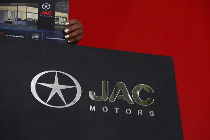 Vendor arranges publicity material of China&#039;s JAC Motors at a dealership in Sao Paulo