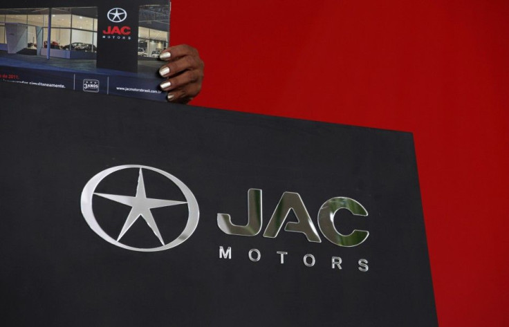 Vendor arranges publicity material of China&#039;s JAC Motors at a dealership in Sao Paulo