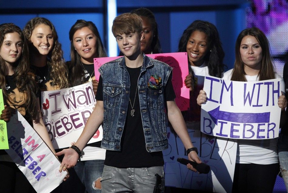 Presenter Justin Bieber stands with a group of fans before announcing best male hip hop artist at the 2011 BET Awards in Los Angeles