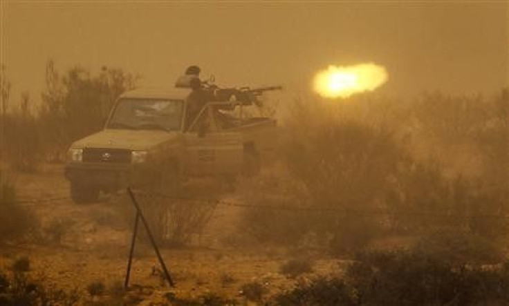 Libyan rebels fire an anti-aircraft gun at government forces during a heavy sandstorm near the village of Tiji in western Libya