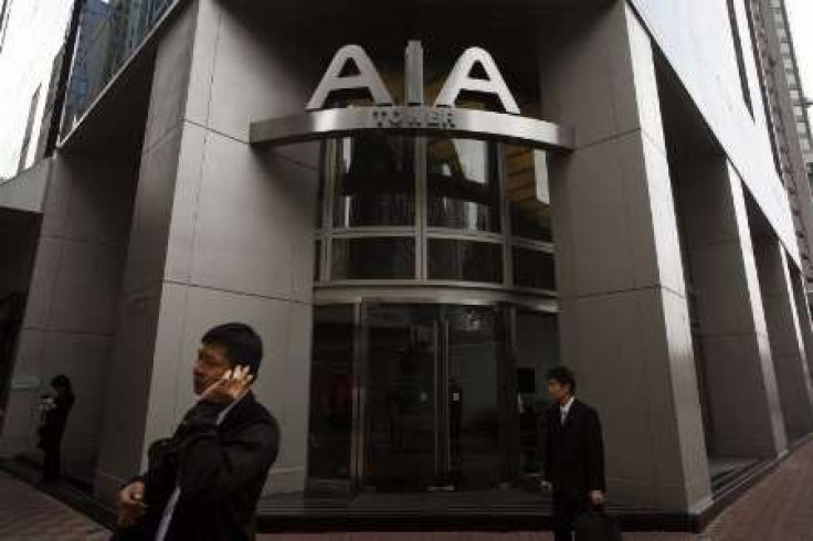 People walk past the AIA Tower, named after American International Assurance Co (AIA), in Hong Kong 