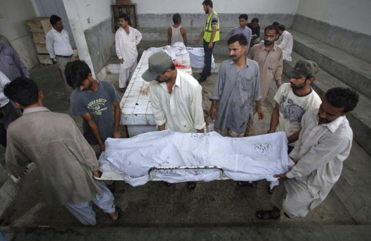 Family members move the body of a man, killed by unidentified gunmen during a shoot out, from morgue in Karachi
