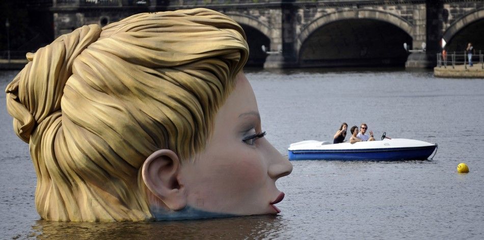 People in a boat look at a sculpture of a mermaid at the 039Alster039 lake in Hamburg