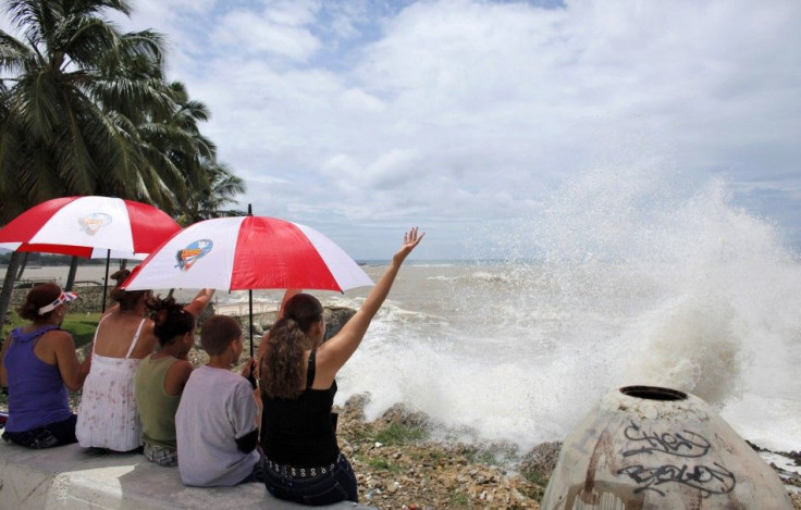 Residents sit at the malecon as Tropical Storm Emily arrives to Santo Domingo