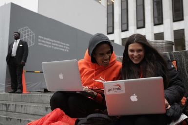 Keenen Thompson and Jessica Mellow surf the web while waiting in line to buy an iPhone 4S at the Apple Store on 5th Avenue in New York