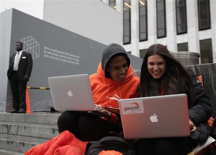 Keenen Thompson and Jessica Mellow surf the web while waiting in line to buy an iPhone 4S at the Apple Store on 5th Avenue in New York