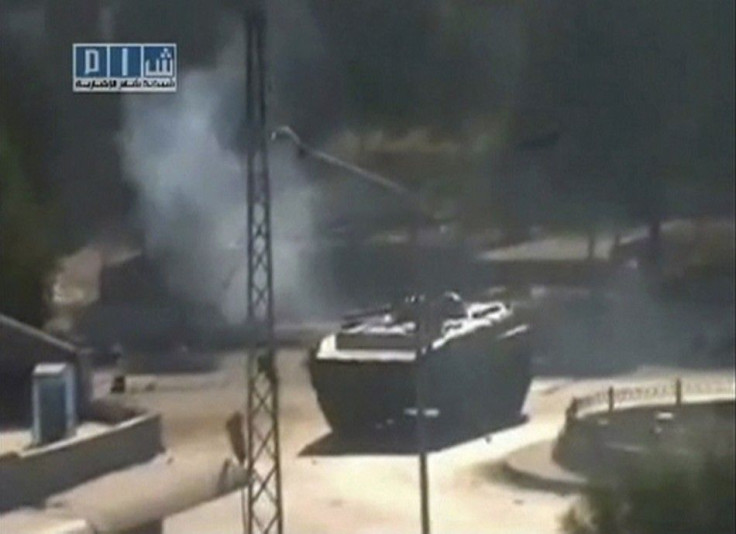 Smoke is seen near a tank at Al-Bahra roundabout in Hama in this still image taken from video