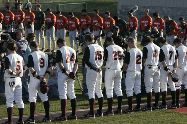 The Virginia Tech baseball team bow their heads during a 32-second moment of silence in Blacksburg 