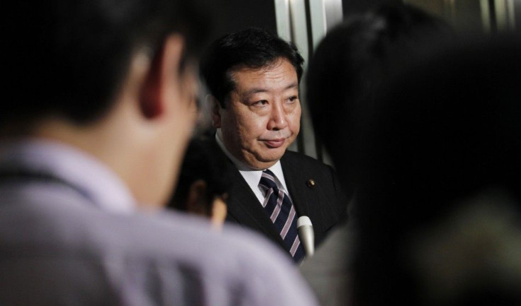 Finance Minister Yoshihiko Noda is surrounded by reporters in Tokyo