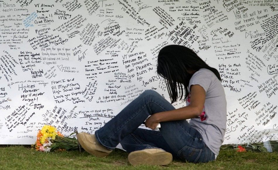 A Virginia Tech student writes a message on a memorial on the campus of Virginia Tech in Blacksburg 