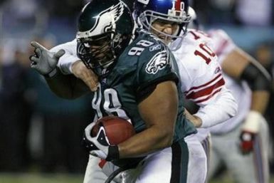 New York Giants quarterback Eli Manning tries to tackle Philadelphia Eagles Mike Patterson (98) after Patterson caught an interception during the first quarter of NFL football game action in Philadelphia
