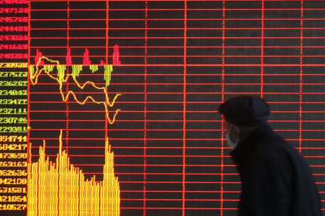 An investor looks at a screen showing stock information at a brokerage house in Taiyuan