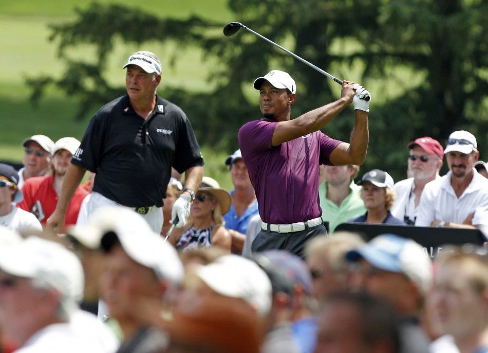 Tiger Woods of the U.S. tees off on the third hole as his playing partner, Northern Ireland039s Darren Clarke looks on during the first round of the WGC Bridgestone Invitational PGA golf tournament at Firestone Country Club in Akron