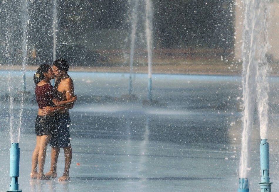 A couple kisses in the Unisphere fountain at the Flushing Meadows-Corona Park in New York