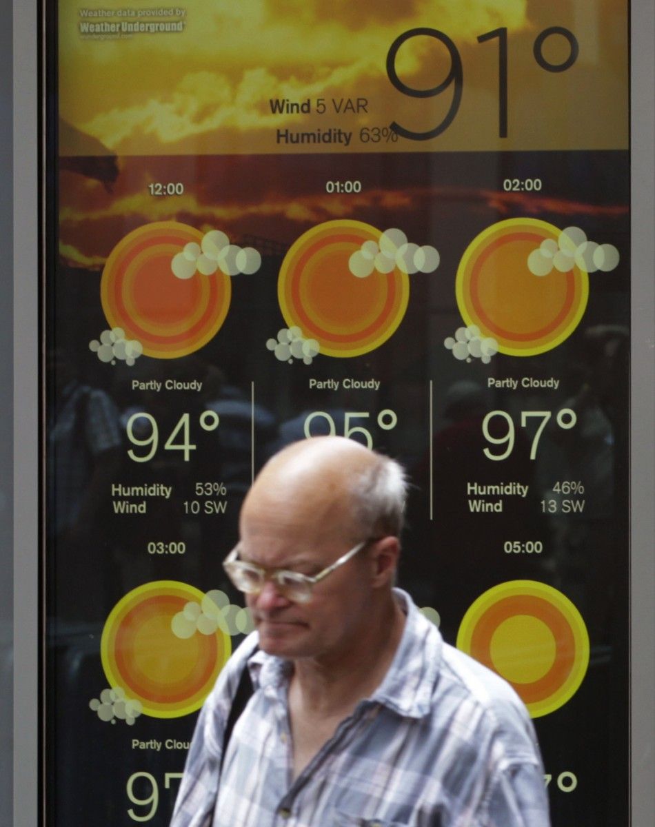 A man walks past a screen that displays the weather forecast and temperature in New York039s Times Square