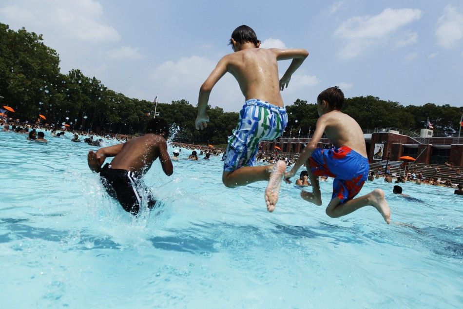 A trio of boys jumps into the Astoria Park Pool in New York