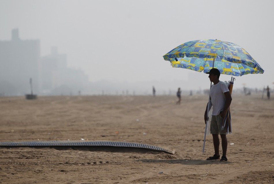 A man stands with an umbrella at Coney Island in the Brooklyn borough of New York