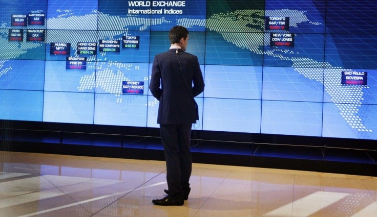 A television journalist looks at a display board shortly after the local market opened at the Australian Stock Exchange in Sydney