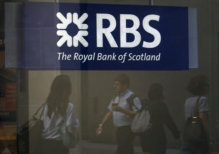 Pedestrians are reflected in the window of a branch of the Royal Bank of Scotland in London